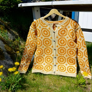May include: A knitted cardigan with a geometric pattern in shades of yellow and white. The cardigan has a button closure and long sleeves.