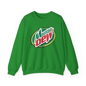 May include: A bright green crewneck sweatshirt featuring the Mountain Dew logo printed on the center of the chest. The logo consists of the word Mountain in dark green and the word Dew in red, set against a yellow and green oval background.