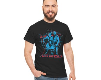 Może przedstawiać: Czarny t-shirt z grafiką retro przedstawiającą trzy postacie w kolorze niebieskim i czerwony helikopter, z napisem "AIRWOLF" w kolorze czerwonym. Projekt umieszczono na niebieskim okręgu.