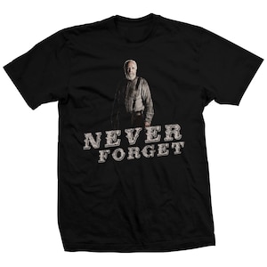 May include: Black t-shirt with a white image of a man with a beard and the text "NEVER FORGET" in white.