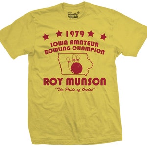 May include: Yellow t-shirt with red text that reads "1979 Iowa Amateur Bowling Champion" and "Roy Munson" with a bowling ball and pins graphic. The text also reads "The Pride of Ocelot".