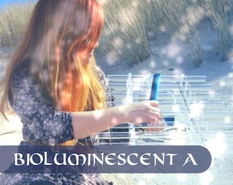 Puede incluir: Un instrumento musical de vidrio transparente con múltiples tubos dispuestos en fila, con el texto A C D F G A C D F en la parte superior y BIOLUMINESCENT A en la parte inferior. El instrumento es sostenido por una persona e incluye un percutor azul.