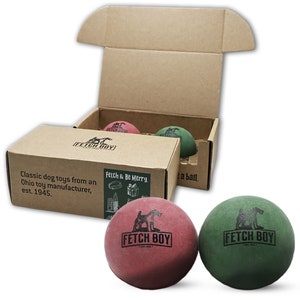 May include: Two rubber dog toys in a cardboard box. The toys are red and green and have the words "Fetch Boy" printed on them. The box has the text "Fetch & Be Merry" printed on it.