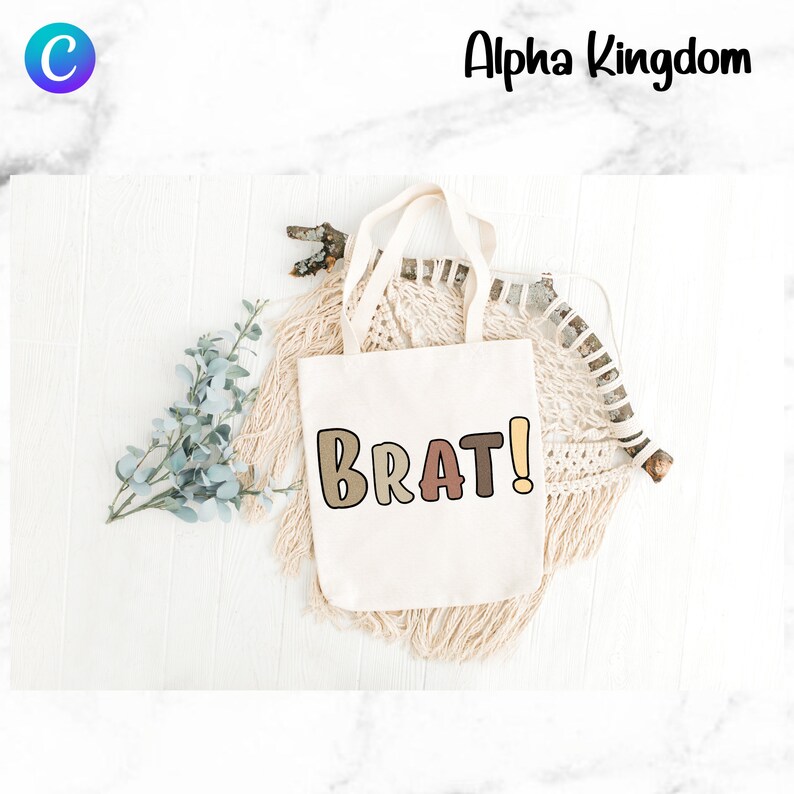 May include: A white tote bag with the word "BRAT!" printed in colorful, outlined letters. The letters are in shades of brown, pink, and yellow.