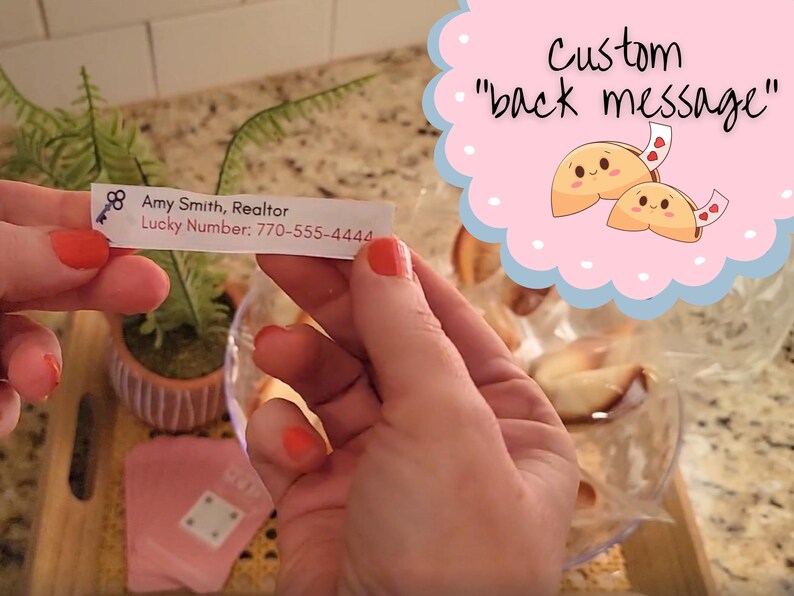 woman holding the custom fortune message showing the back of the message with the bowl of fortune cookies in the background