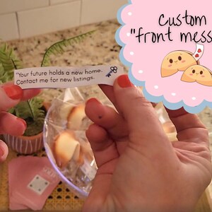 woman holding the custom fortune message showing the front of the message with the bowl of fortune cookies in the background