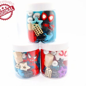 May include: Three clear plastic jars filled with red, blue, and black play dough. Each jar contains various small toys, including a Spiderman figure, a star, a building, and a spider.