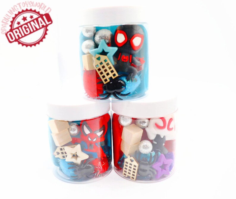 May include: Three clear plastic jars filled with red, blue, and black play dough. Each jar contains various small toys, including a Spiderman figure, a star, a building, and a spider.