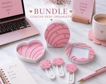 May include: A Concha desk organizer bundle featuring pink and tan bread-patterned accessories including a heart-shaped tray, a circular holder, a square sticky note holder, and three large paper clips, all arranged on a white surface.