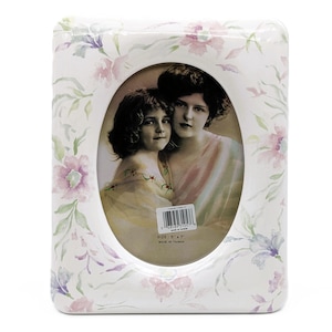Peut inclure: Cadre photo en céramique blanche avec une ouverture ovale et un motif floral. Le cadre mesure 12,7 cm sur 17,8 cm et est fabriqué à Taiwan.