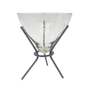 May include: A clear glass vase with a textured surface sits on a black metal stand with three legs.