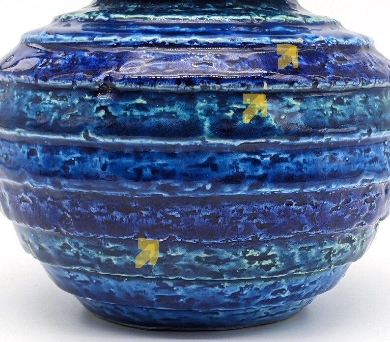 Op de afbeelding: Een blauwe en groene keramische vaas met een getextureerd, gestreept ontwerp. De vaas heeft een ronde vorm en een brede opening.