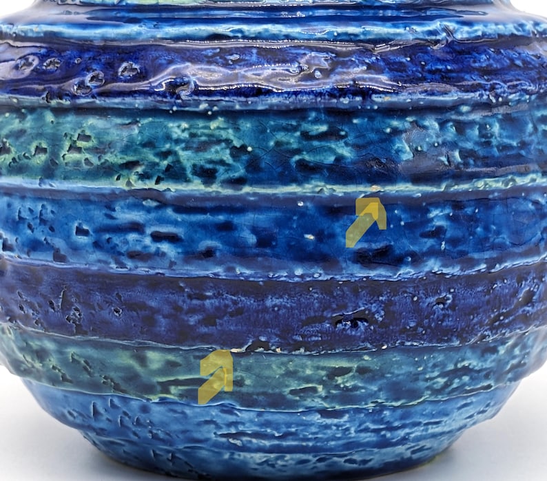 Op de afbeelding: Een blauwe en groene keramische vaas met een getextureerd, gestreept ontwerp. De vaas heeft een ronde vorm en een brede opening.