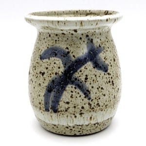 Può includere: Un piccolo vaso in ceramica marrone e bianco con un design astratto blu. Il vaso ha una smaltatura macchiata e una forma arrotondata.