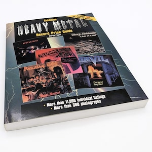 May include: A book titled "Goldmine Heavy Metal Record Price Guide" with a black and white lightning bolt design on the cover. The cover features album covers from various heavy metal bands, including Little Suzy, Telephone, Poison, and Anvil.