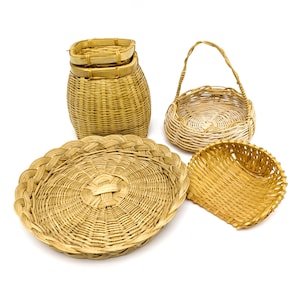 May include: A set of five woven wicker baskets in various shapes and sizes. The baskets are made of natural, light brown wicker and are perfect for storage or display.