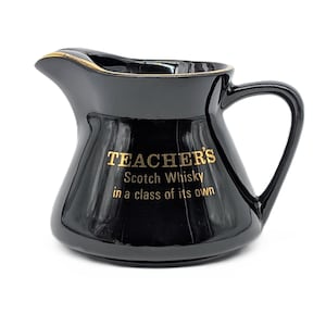 Puede incluir: Jarra de cerámica negra con borde y asa dorados. La jarra tiene la inscripción dorada "TEACHER'S Scotch Whisky in a class of its own". Diseñada para servir whisky.
