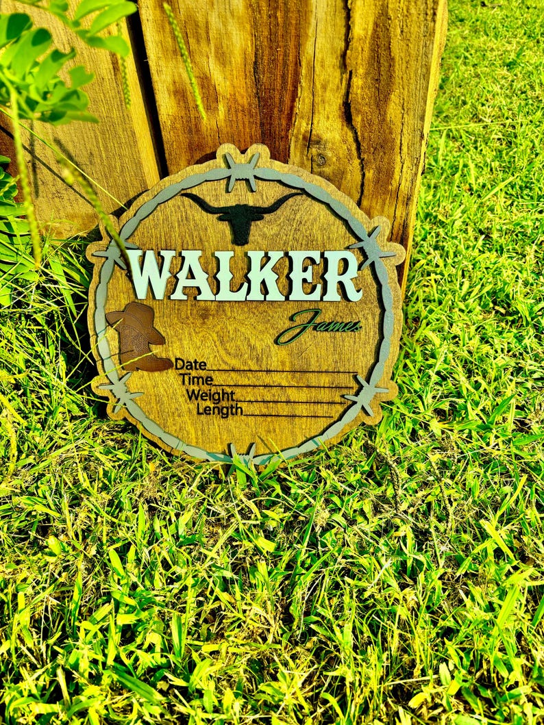 May include: A wooden sign with a barbed wire border and a silhouette of a longhorn steer. The sign says "WALKER James" and has spaces to fill in the date, time, weight, and length.