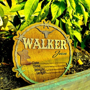 May include: A wooden sign with a cowboy hat and a longhorn design. The sign says "WALKER" and has a space for a name, date, time, weight, and length.