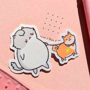 Autocollant drôle mignon de chat | chat qui promène un chien shiba | Sticker mat brillant holographique | cadeau pour amoureux des chats, enfants, enfants