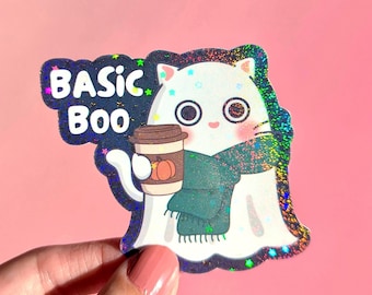 Op de afbeelding: Een holografische sticker met een witte spookkat met een groene sjaal, die een koffiekopje met een pompoenontwerp vasthoudt. De sticker heeft de woorden "BASIC BOO" in een donkerblauwe bubbel.