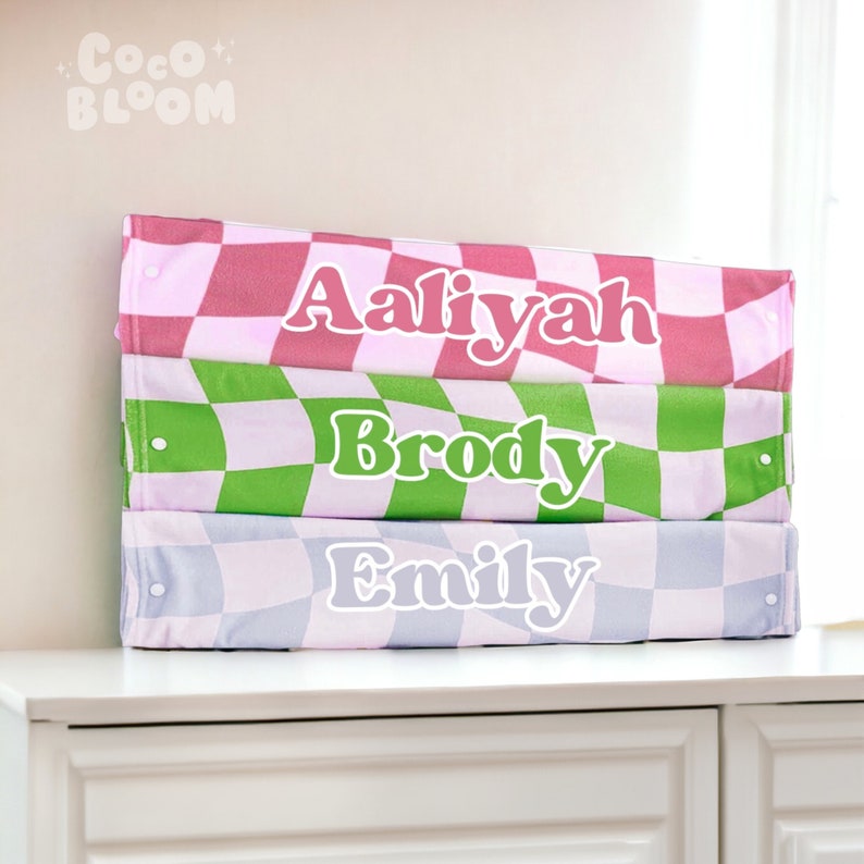 Peut inclure: Trois bacs de rangement empilables avec des motifs &agrave; carreaux en rose, vert et bleu. Chaque bac porte un nom : Aaliyah, Brody et Emily.