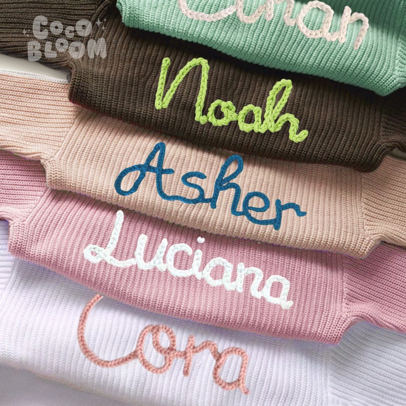 May include: A stack of five knitted sweaters with different names embroidered on them in various colors. The names are "Coma", "Luciana", "Asher", "Noah", and "Olivia".