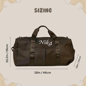 May include: Black duffel bag with the name "Nika" in white script. The bag is 46cm long, 26cm high, and 20cm wide. The word "SIZING" is at the top.