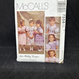 May include: A McCall's 7556 sewing pattern envelope for size 6, featuring Ann Hallay Designs Counterchange. The front displays three children in various dresses with puffed sleeves and smocked bodices, alongside three smaller inset photos.