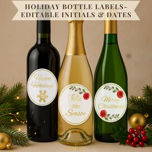 May include: Three bottles of wine and champagne with holiday-themed labels. The labels feature gold text and accents, with phrases like "Happy Holidays" and "Merry Christmas." The bottles are arranged in front of festive decorations.