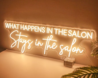 May include: White neon sign with the text "What happens in the salon stays in the salon".