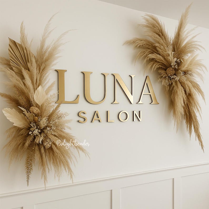 以下が含まれることがあります： 白い壁に設置された、金色の文字で「LUNA SALON」と書かれた看板。乾燥したパンパスグラスと花の装飾が施されています。壁には腰壁のデザインがあります。美容院の装飾です。
