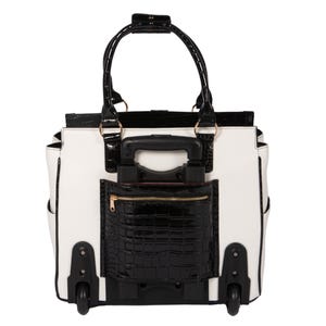Back view of a wheeled work tote in white and black patent faux leather, featuring a retractable handle hidden in a zippered compartment providing easy access to chargers, phone, or passport. This rolling office bag for women is perfect for teachers, lawyers, or busy professionals on the go. Makes a great gift for working moms or travelers who need a rolling computer bag that’s both durable and elegant. Smooth-rolling all-terrain wheels make this the best women’s laptop bag for travel and work.