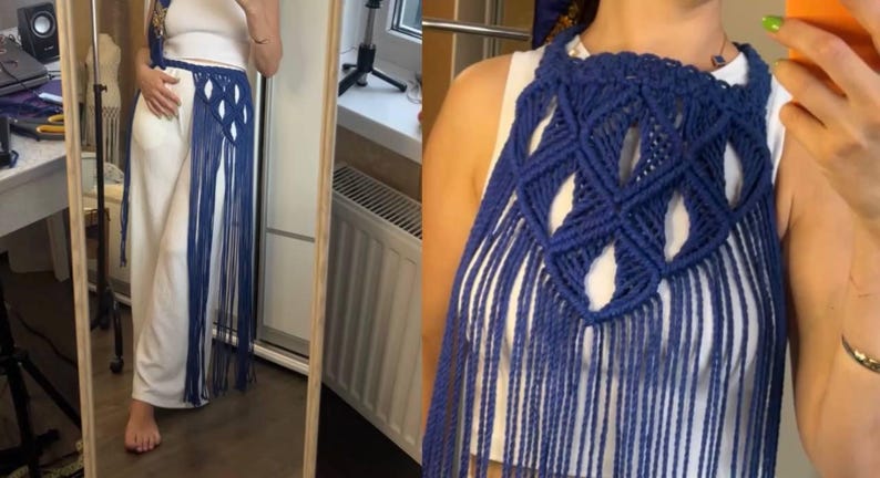 May include: A dark blue macrame accessory featuring an intricate diamond-shaped knotted pattern with long, flowing fringe. The piece is designed to be worn over a white top, creating a layered look with its textured cord construction and open weave.