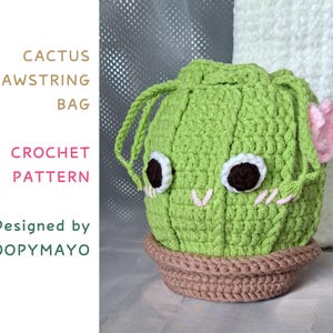 Puede incluir: Bolso de cordón de cactus de crochet verde con detalles de flores rosas y maceta marrón. El bolso tiene una cara linda con ojos blancos y costuras rosas. El texto "Cactus Drawstring Bag Crochet Pattern Designed by Loopymayo" está en el lado izquierdo de la imagen.