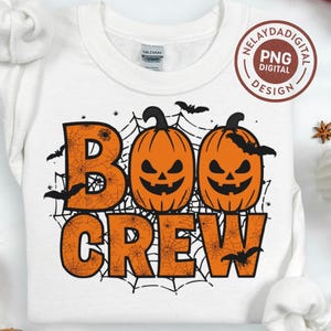 May include: White sweatshirt with a Halloween-themed graphic. The design features the words "BOO CREW" in orange, with a spiderweb pattern and two orange jack-o'-lanterns. Bats are scattered around the design. A "PNG DIGITAL DESIGN" logo is in the upper right corner.