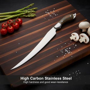 Puede incluir: Un cuchillo para filetear de acero inoxidable con mango de madera descansa sobre una tabla de cortar de madera oscura. Espárragos, tomates cherry, champiñones y sal están dispuestos alrededor del cuchillo. El texto en la imagen dice: High Carbon Stainless Steel.