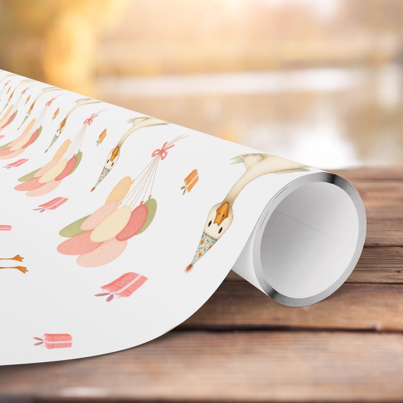 May include: White wrapping paper featuring watercolor illustrations of geese wearing party hats and holding balloons. The balloons are in shades of pink, peach, and green. Small gift boxes and bows are also scattered across the paper.