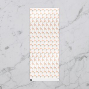 May include: A rectangular white fabric with a repeating pattern of small, stylized flowers in peach and gold, interspersed with tiny pink and blue dots. The design is delicate and feminine, creating a soft, watercolor effect.