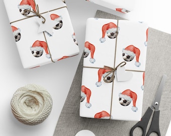 Carta da regalo natalizia con palloni da calcio: cappelli di Babbo Natale rossi