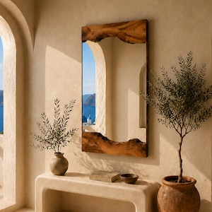 May include: A rectangular wall mirror featuring a natural live edge wood frame with organic, uneven contours on the top and bottom edges. The reflective glass surface is framed by dark brown, textured wood grain, mounted on a smooth beige wall.