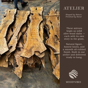 May include: Several raw, solid olive-wood slabs with natural live edges, prominent wood grain, and dark knots. The text on the right reads: ATELIER, Shaped by Nature, Finished by Hand, These mirrors begin as solid olive-wood slabs, WOODYVIBES.