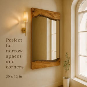 May include: A rectangular wall mirror featuring a natural live edge wood frame on the top and bottom edges. The mirror measures 20 x 12 inches. The text on the wall reads: Perfect for narrow spaces and corners. 20 x 12 in.