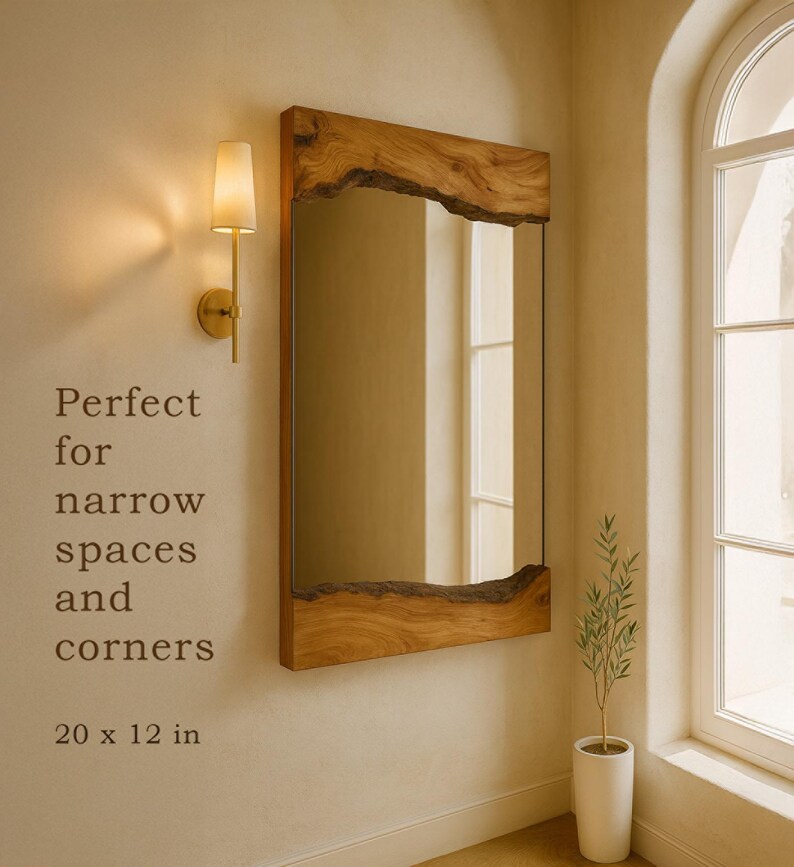 May include: A rectangular wall mirror featuring a natural live edge wood frame on the top and bottom edges. The mirror measures 20 x 12 inches. The text on the wall reads: Perfect for narrow spaces and corners. 20 x 12 in.