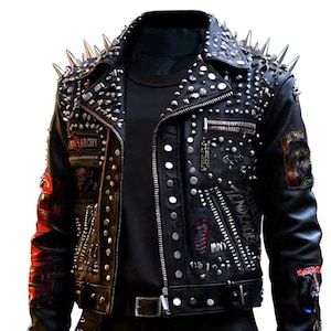 Könnte beinhalten: Schwarze Lederjacke mit silbernen Nieten und Spikes. Die Jacke hat mehrere Patches, darunter ein Rolling Stones Zungenlogo, ein "Seventeen Seconds" Patch und ein "Misfits" Patch.