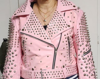May include: A pink leather jacket with silver studs and spikes. The jacket has a zipper closure and a belt.