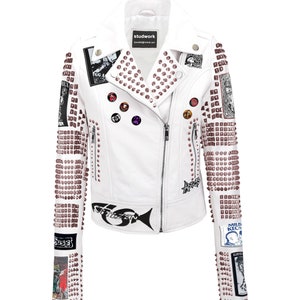 May include: White leather biker jacket with silver studs and various patches, including a fish graphic, a skull graphic, and the text "studwork".