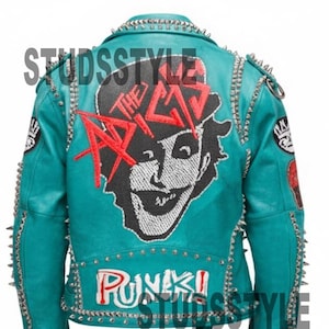 May include: Teal leather jacket with silver studs and spikes. The back features a graphic of a face with the text "THE AXE" in red. The word "PUNK!" is also displayed. Zippers and a belt complete the design.