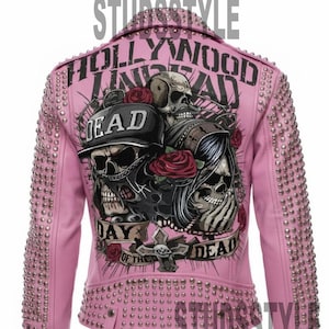 May include: Pink leather jacket with silver studs and a graphic of skulls, roses, and the text "Hollywood Undead" and "Day of the Dead". The jacket has a zipper on the sleeves.