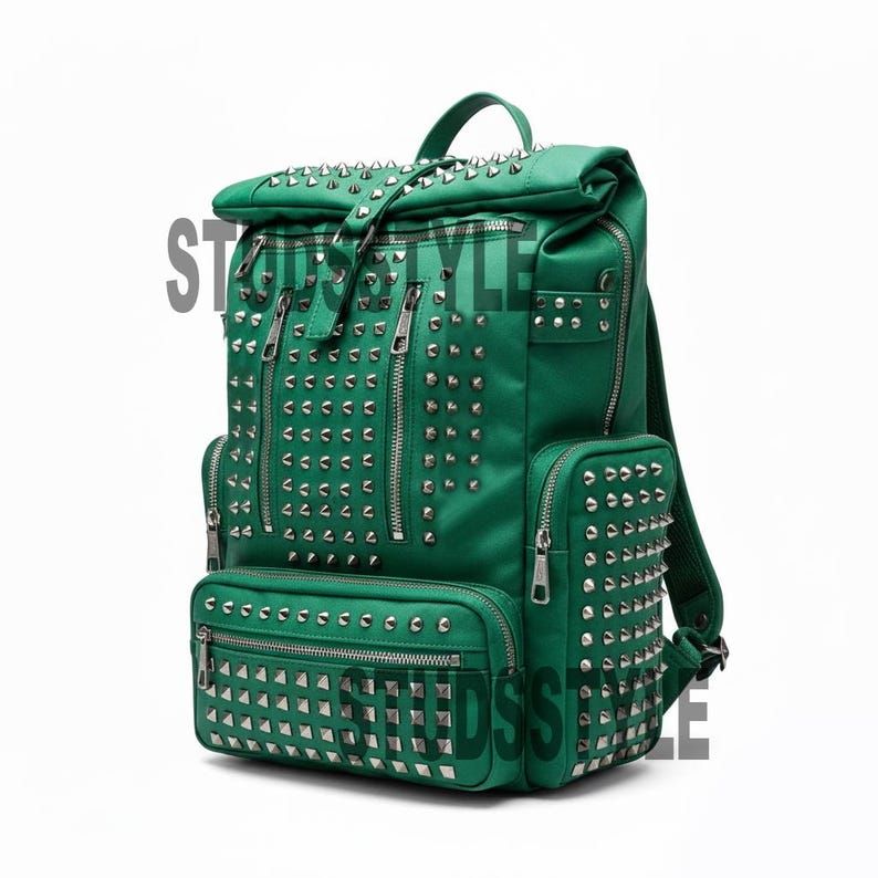 May include: Green backpack with silver-colored studs and multiple zippered compartments. The backpack has a top handle and adjustable straps. The word "STYLE" is partially visible on the left side of the bag.